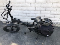 a black electric bike with a backpack attached to it